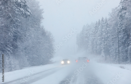Cars in heavy snowstorm with weak visibility