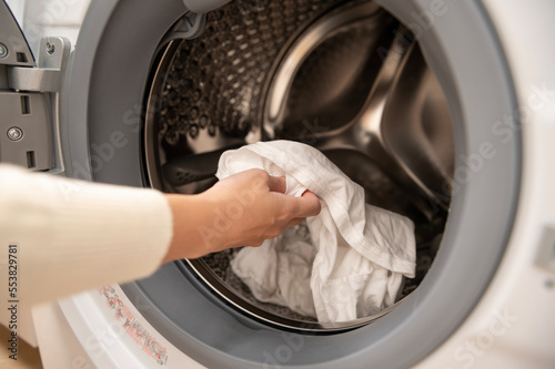 Fotografía Close-up woman hand is keeping clothes in washing  machine , health care lifesty