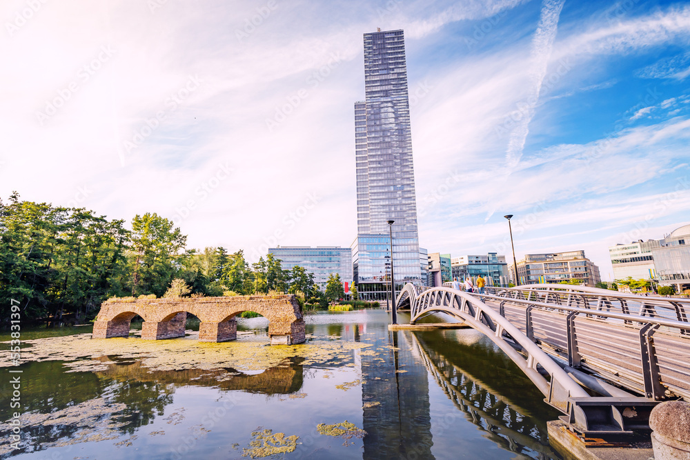 Fototapeta premium MediaPark in Cologne city - is a popular and modern district with pond, roman viaduct, skyscrapper and other buildings accommodating number of media companies