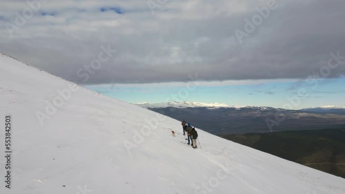 Drone cinematic view on group of people on snowshoes climbs a snowy mountain photo