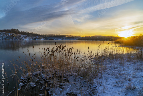 Sunset in winter on the shore of a freezing lake.