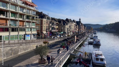 People walking by the Meuse river in Dinant, Belgium