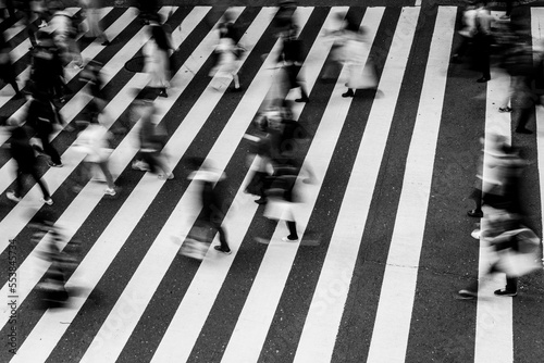 師走の大阪の街。横断歩道を渡る人々が足早に通り過ぎる。モノクロで撮影