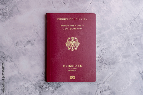 German passport on marble floor. Isolated german passport. Travel to Germany. Travel documents and passports. Visa papers and documents. Immigration and refugee.