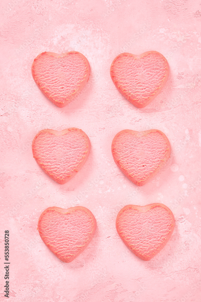 Valentine day decorated heart shaped cookies on pink background, top view