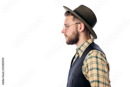 Side-view portrait of young trendy male in cowboy hat stadning isolated on white background © MYDAYcontent