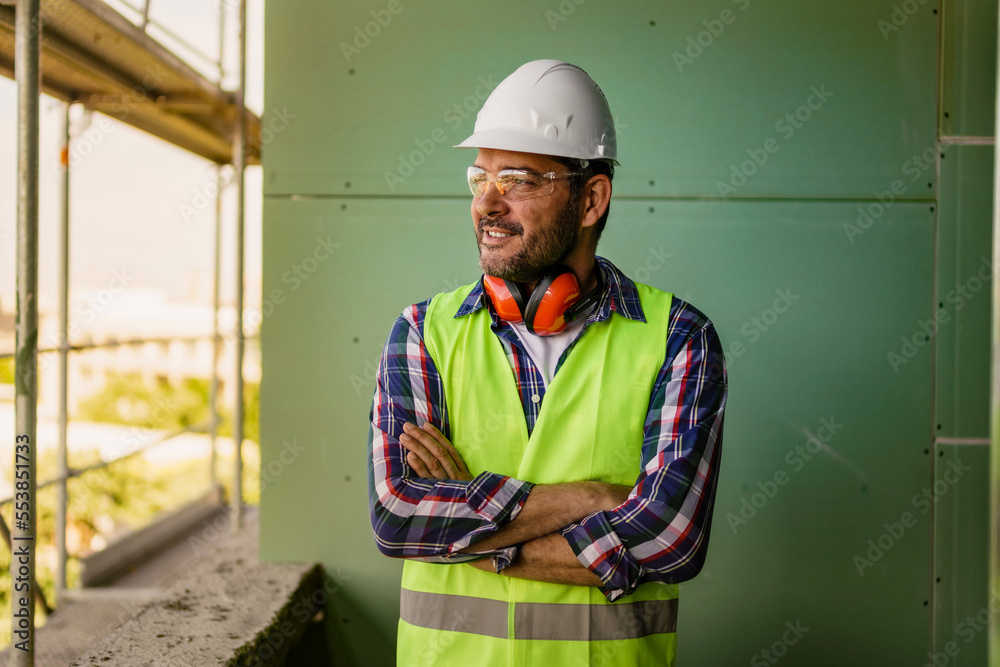 Portrait of men in 40s, construction worker. He is standing in construction and posing for camera. Portrait of men in 40s, construction worker. He is standing in construction and posing for camera.