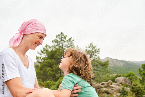 Schilderij op canvas Mother with cancer and son looking at each other relaxed on the mountain