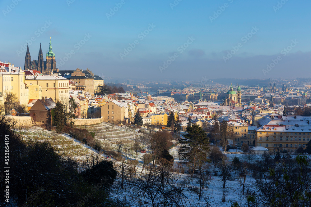 Snowy Prague City with gothic Castle from Hill Petrin in the sunny Day, Czech republic Snowy Prague City with gothic Castle from Hill Petrin in the sunny Day, Czech republic