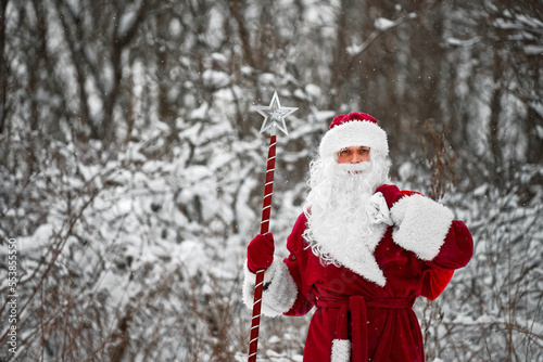 Santa Claus with magic staff and sack of Christmas gifts.