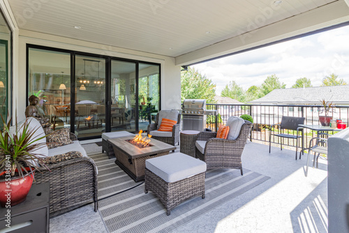 Fototapete A luxurious spacious deck with stylish patio furniture and a table fire-pit heat