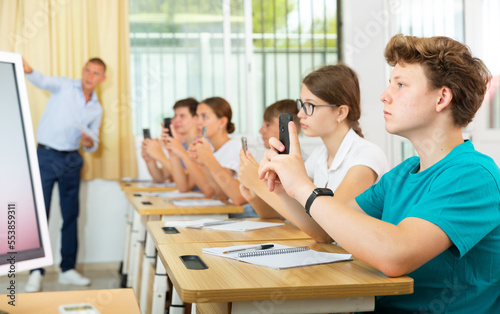 Classmates using their smartphones heavily during classes