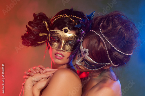 Fototapeta Naklejka Na Ścianę i Meble -  Couple of sensual women with colorful makeup and carnival masks