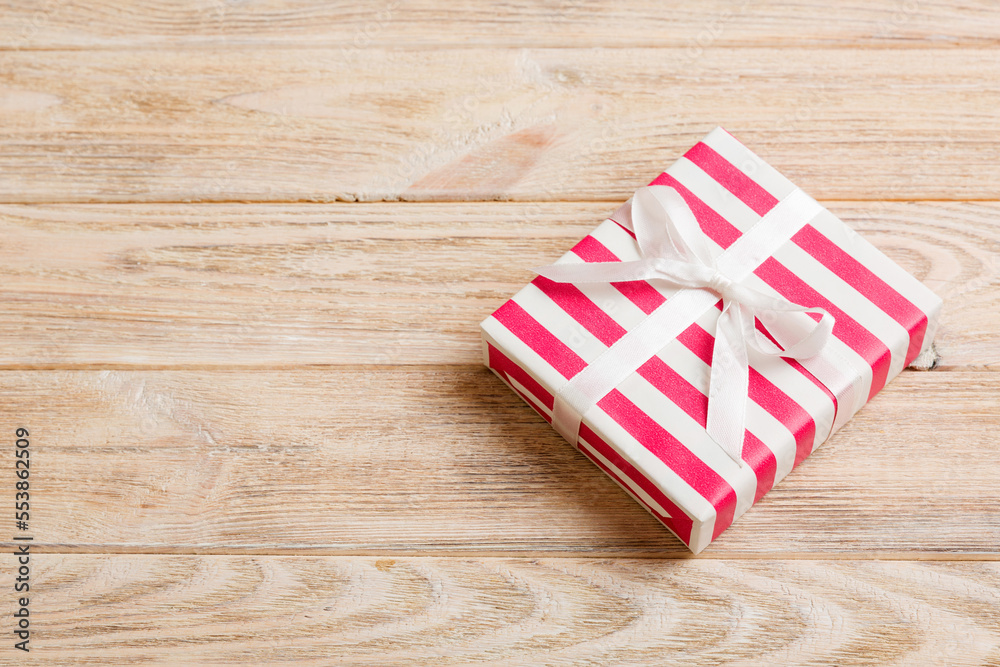 wrapped Christmas or other holiday handmade gift box in color paper with ribbon on colored background. Present box, decoration of gift on colored table, top view with copy space wrapped Christmas or other holiday handmade gift box in color paper with ribbon on colored background. Present box, decoration of gift on colored table, top view with copy space