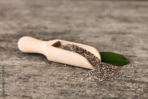 Wooden spoon and chia seeds on colored background, top view. Healthy Salvia hispanica Healthy superfood