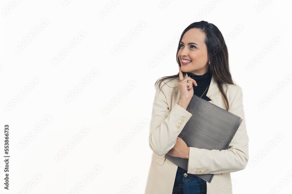 Latin american young businesswoman standing holding document folder holding one hand to her face in thinking expression looking at top left corner smiling. White background copy space horizontal Latin american young businesswoman standing holding document folder holding one hand to her face in thinking expression looking at top left corner smiling. White background copy space horizontal