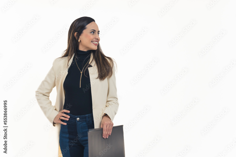 Fashionable latin american businesswoman standing with hand on hip holding document folder looking to the side smiling. Business owner manager. White background copy space horizontal studio shot. High Fashionable latin american businesswoman standing with hand on hip holding document folder looking to the side smiling. Business owner manager. White background copy space horizontal studio shot. High