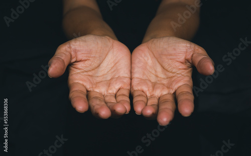 Foto Woman with open hands praying for God's blessing in black background