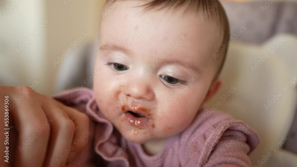 baby newborn eats. dirty mess baby girl eating vegetables. baby daughter eats on a feeding chair dirty face. naughty dirty babe indulges while feeding. happy indoors kid dream family weaning concept baby newborn eats. dirty mess baby girl eating vegetables. baby daughter eats on a feeding chair dirty face. naughty dirty babe indulges while feeding. happy indoors kid dream family weaning concept