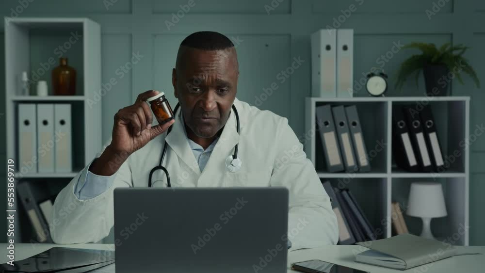 Experienced doctor elderly age African man general practitioner talk video call via computer conference app consult sick patient online recommend vitamin pills health medication cardiovascular tablets