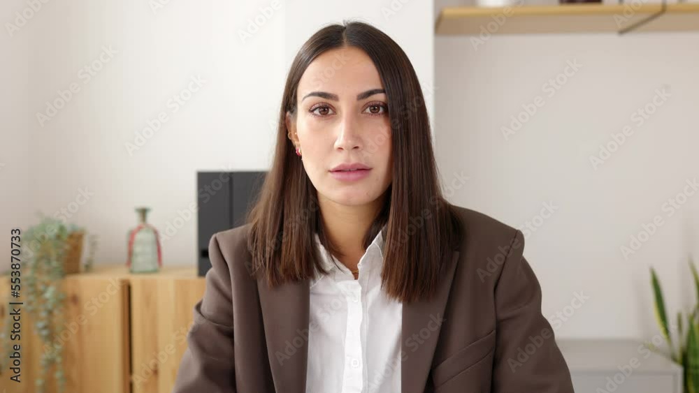 Video confident portrait of serious business woman sitting at desk office. Front view portrait of pretty female entrepreneur looking at camera. Successful people concept Video confident portrait of serious business woman sitting at desk office. Front view portrait of pretty female entrepreneur looking at camera. Successful people concept