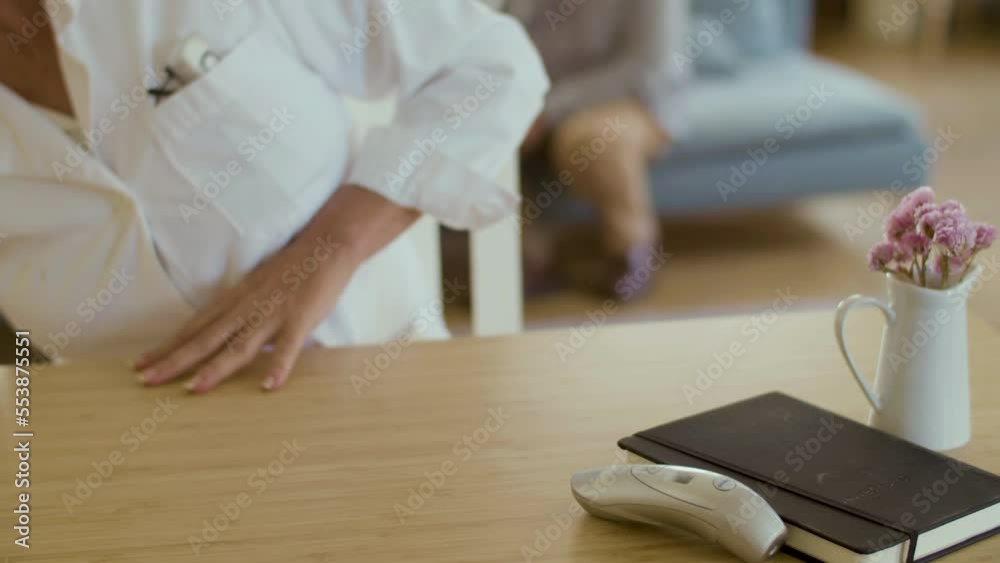 Close-up shot of unrecognisable therapist filling in documents. Female doctor in medical uniform having appointment at home, preparing for vaccination procedure. Covid, pandemic concept Close-up shot of unrecognisable therapist filling in documents. Female doctor in medical uniform having appointment at home, preparing for vaccination procedure. Covid, pandemic concept