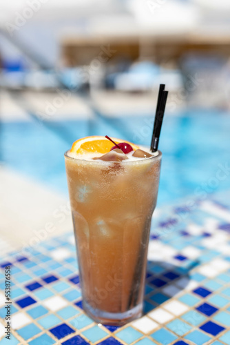 Frozen Margarita or Daiquiry Fresh cocktail drink at the poolside outdoors, nobody. Vacation, summer, holiday, luxury resort concept. Coral shade drink. Vertical