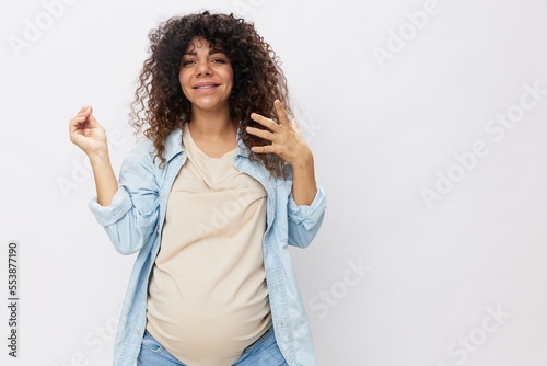 Pregnant woman happiness dancing smile, Mother's Day last month before childbirth on white insulated background in t-shirt with blue shirt