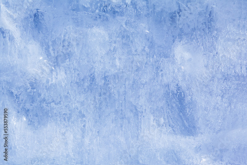 Texture of winter ice on a stone cliff. Blue natural ice background