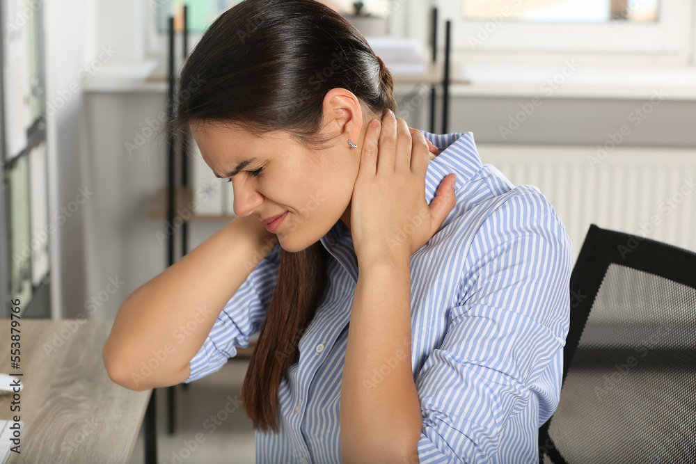 Young woman suffering from neck pain in office Young woman suffering from neck pain in office