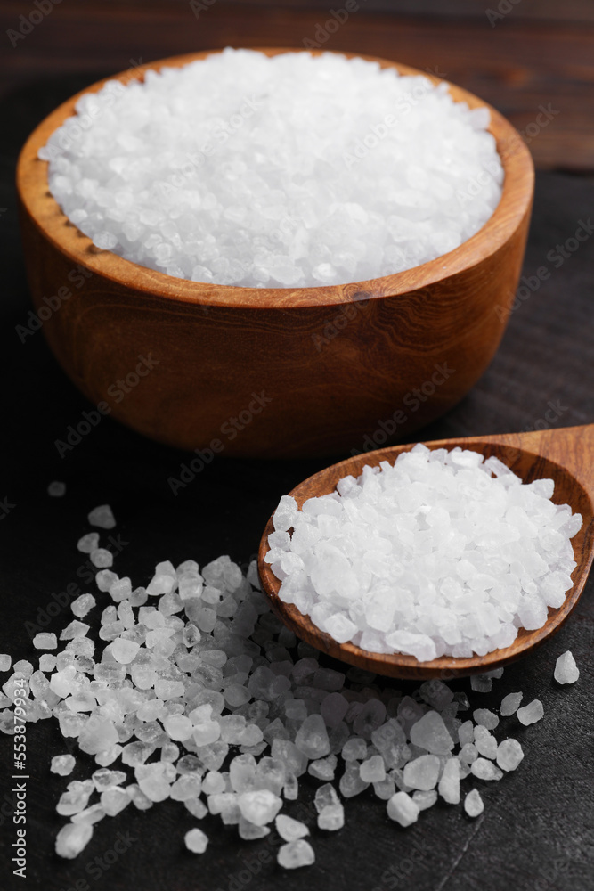 Spoon and bowl of natural sea salt on wooden table, closeup Spoon and bowl of natural sea salt on wooden table, closeup
