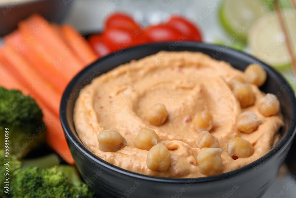 Bowl with delicious hummus and fresh vegetables, closeup