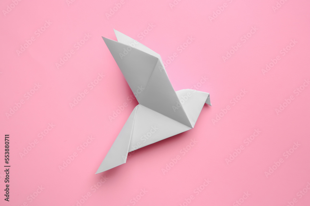 Fototapeta premium Beautiful origami bird on pink background, flat lay