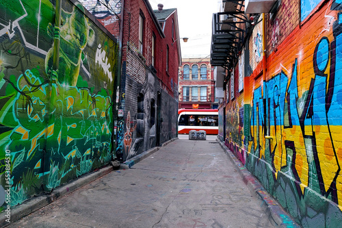 Toronto graffiti alley - Abstract colourful graffiti paintings on concrete walls.  Street art, background, texture. © Elton