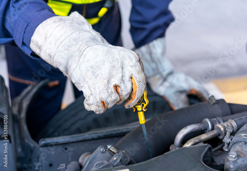 Closeup of mechanic's hands checking oil engine.