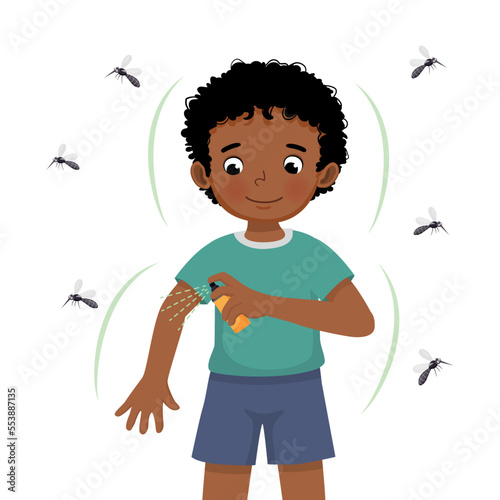 Cute little African boy applying insect repellent spray to his arm as protection against mosquitoes