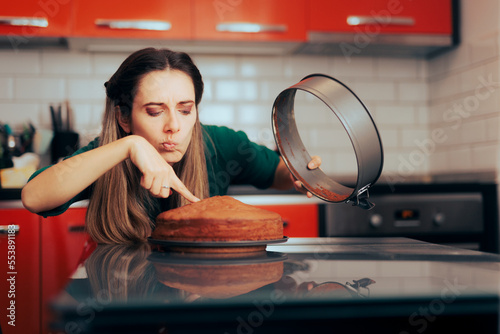 Woman Analyzing Uneven Cake with a Bump in the Middle. Perfectionist cook feeling disappointed with her sponge cake
 photo