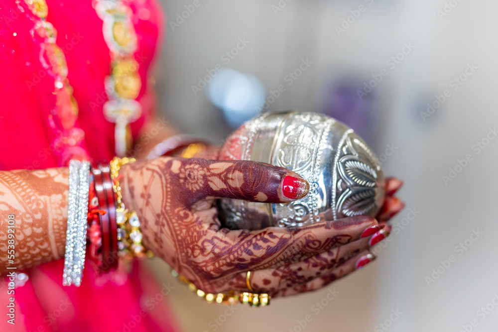 Indian Hindu bride's hands holding a ritual item close up