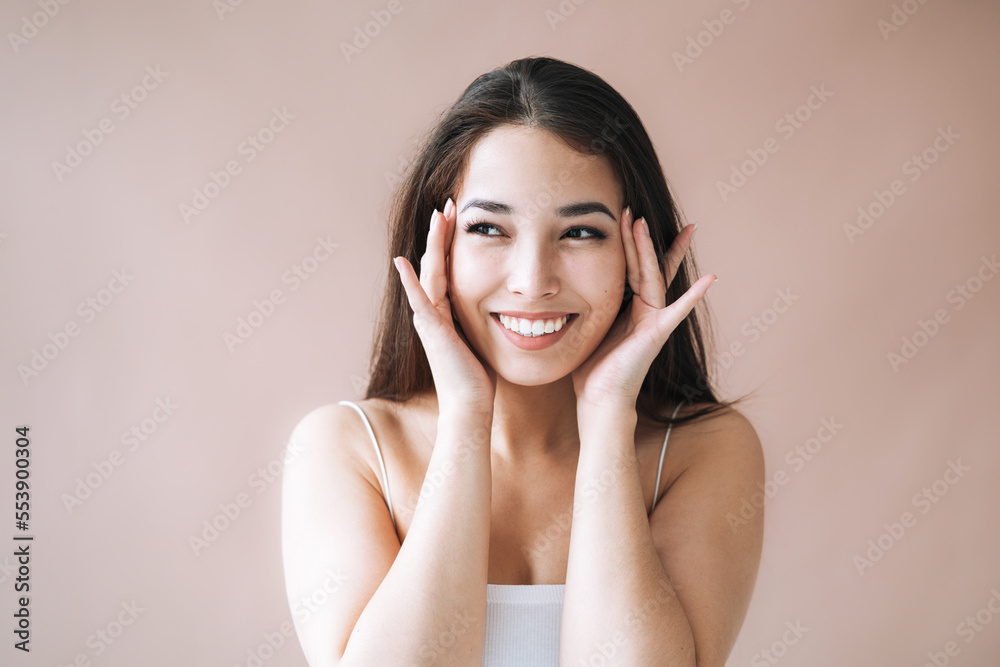 Beauty portrait of young asian woman with healthy dark long hair in top on beige background Beauty portrait of young asian woman with healthy dark long hair in top on beige background