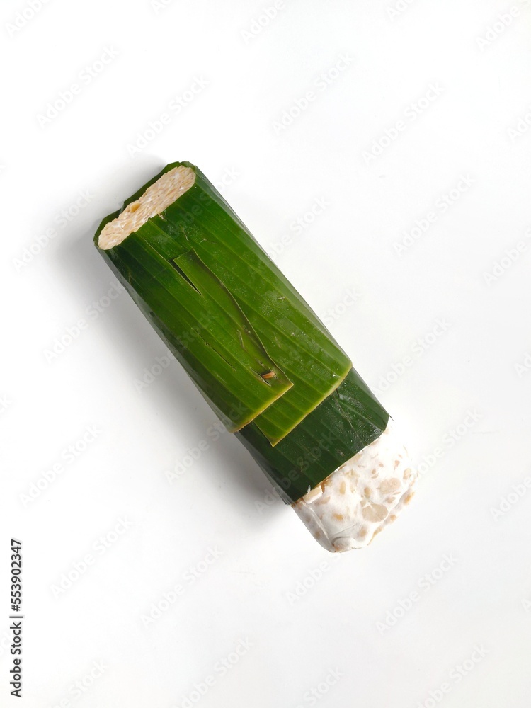 Whole size tempe or tempeh that is covered by banana leaves. Isolated on white background can be used as blank space for free text field. Top view. Whole size tempe or tempeh that is covered by banana leaves. Isolated on white background can be used as blank space for free text field. Top view.