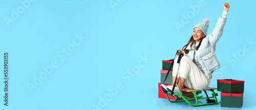 Happy young woman with sled...