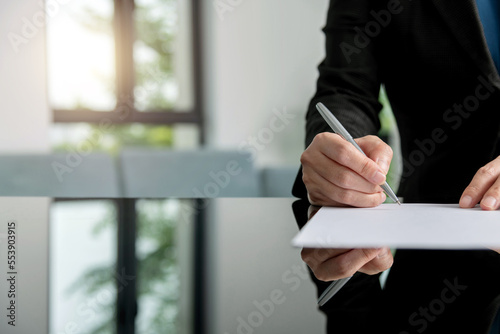 Businesswoman hand writing on paper photo