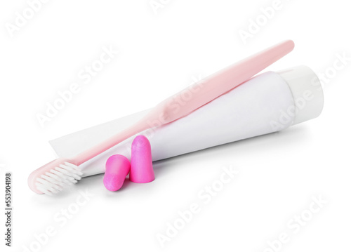 Ear plugs, toothbrush and paste on white background