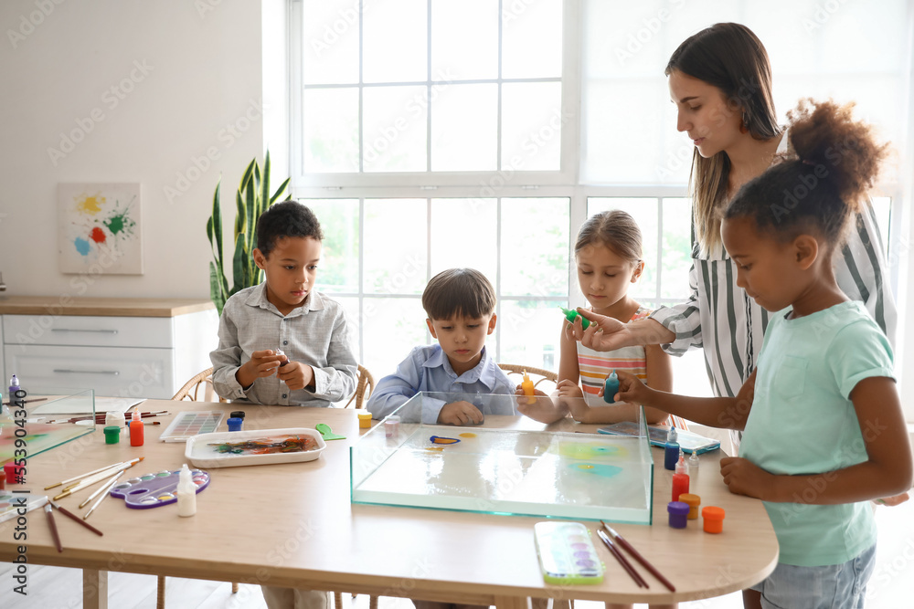 Little children with teacher during master class in Ebru painting at workshop Little children with teacher during master class in Ebru painting at workshop