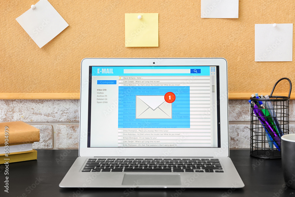 Modern laptop with opened e-mail box on dark table Modern laptop with opened e-mail box on dark table