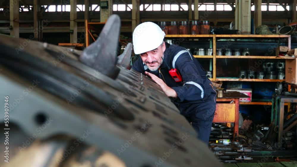 Engineer in the process of inspecting train engines Keep the machine ready for use in the train station. Engineers wear safety clothing and helmets to work safely as standard.
