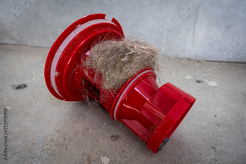 Household vacuum cleaner filter clogging up with dust, mite, hair, and animal fur after an extensive household cleaning : allergy, unhygienic concept photo