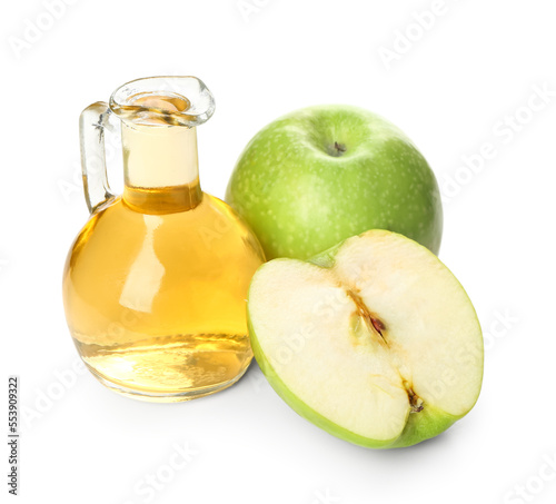 Jug of fresh apple cider vinegar and fruits on white background