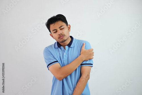 young asian man blue t shirt gesture pain his shoulder or arm in pain isolated on white background