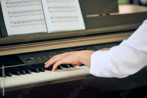 фотографія Woman plays electric piano at outdoor music performance, close up view to pianist nimble hands